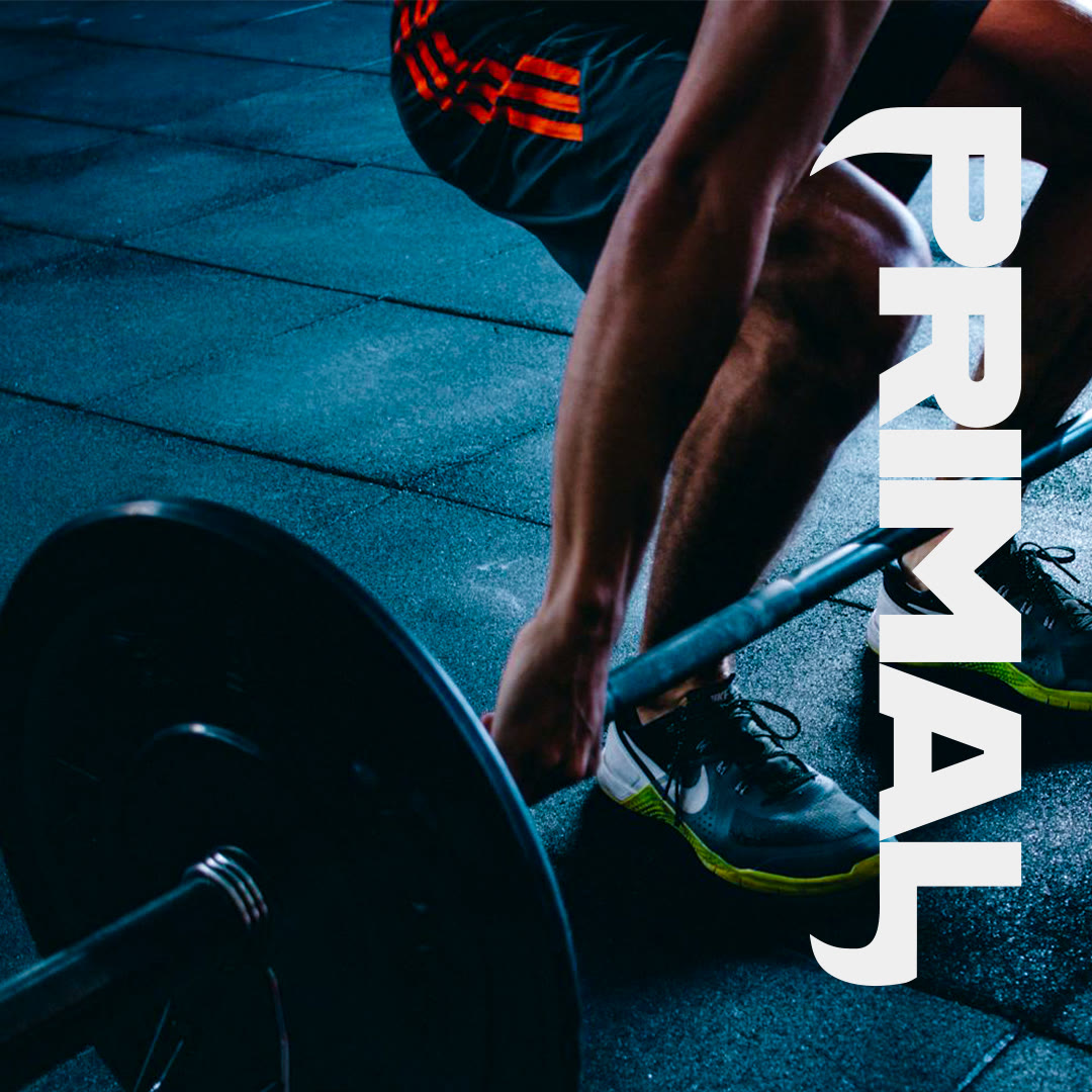 Primal Fitness social post: a lifter gripping a barbell beside the vertical Primal wordmark
